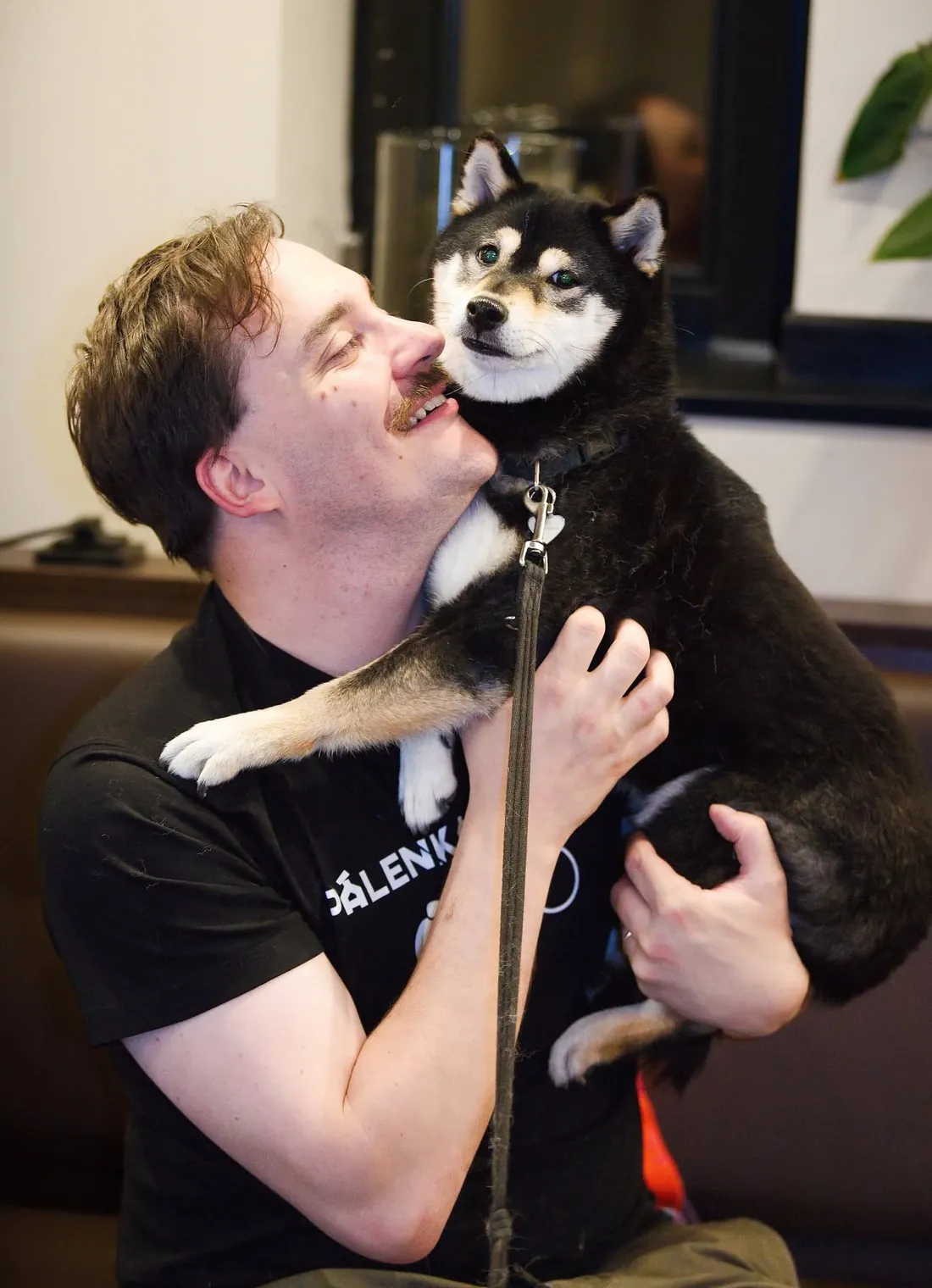 Návštěvník festivalu se psem v náručí